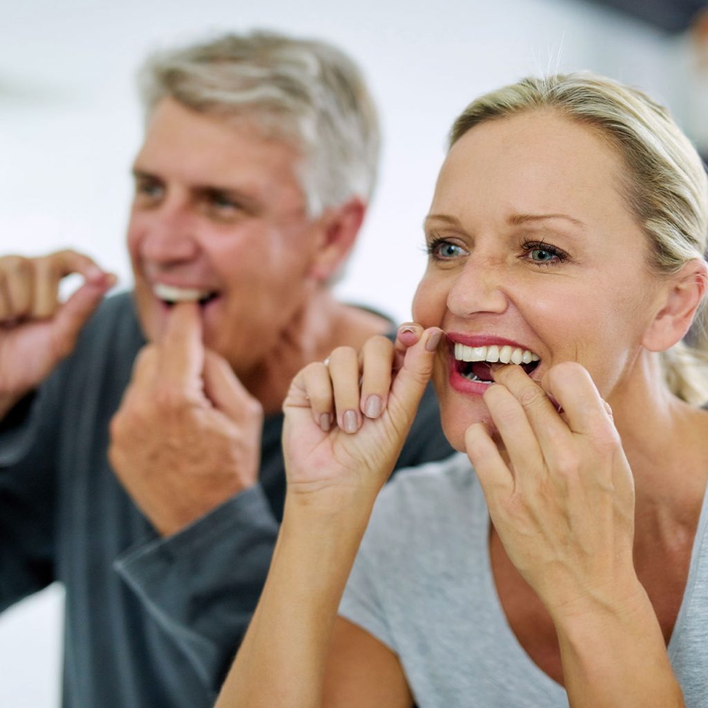 elderly dental patients flossing their teeth